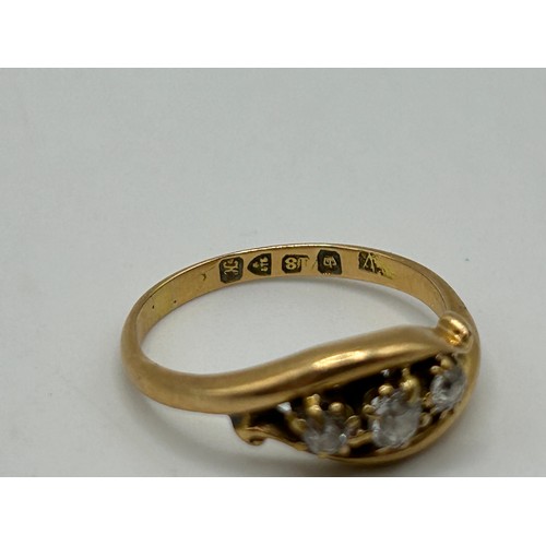 57 - An 18ct gold and three stone diamond ring, ring size M