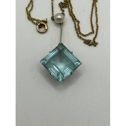 11 - An Art Nouveau style aquamarine and seed pearl pendant, on a yellow metal chain