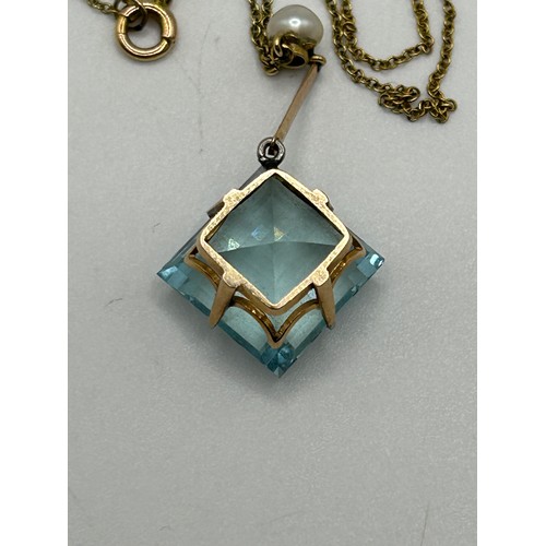 11 - An Art Nouveau style aquamarine and seed pearl pendant, on a yellow metal chain