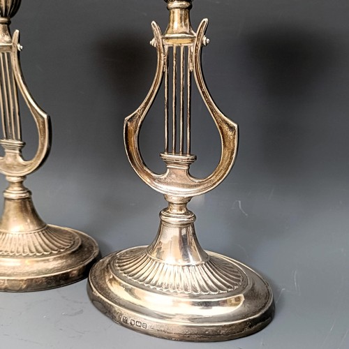 380 - A pair of George V silver candlesticks, the stems in the form of harps, bases filled, Sheffield 1912... 