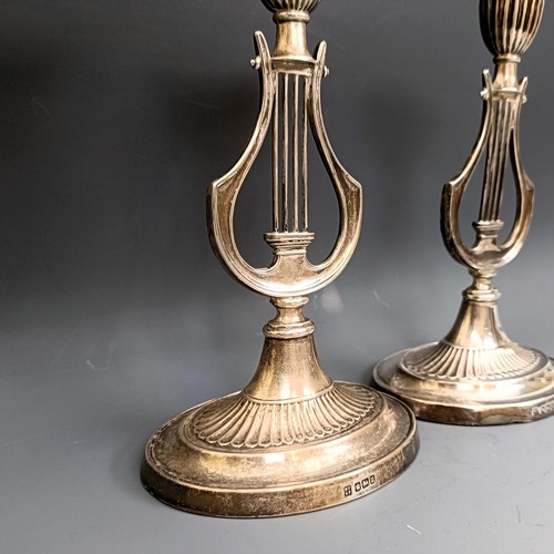 380 - A pair of George V silver candlesticks, the stems in the form of harps, bases filled, Sheffield 1912... 