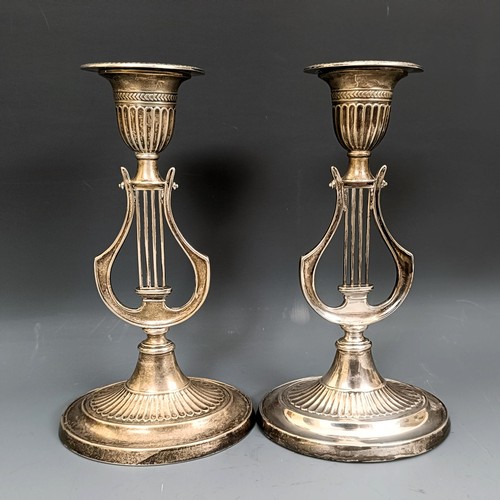 380 - A pair of George V silver candlesticks, the stems in the form of harps, bases filled, Sheffield 1912... 