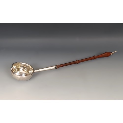 379 - An 18th century silver coloured metal and turned wood toddy ladle, 42 cm wide