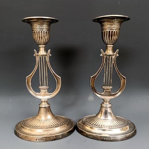 380 - A pair of George V silver candlesticks, the stems in the form of harps, bases filled, Sheffield 1912... 