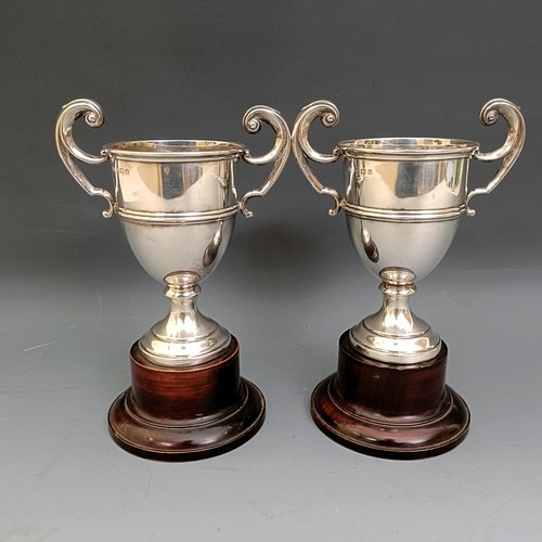 556 - A pair of modern silver two handled trophy cups, 4.7 ozt, 11.5 cm high, on turned wooden stands, Lav... 