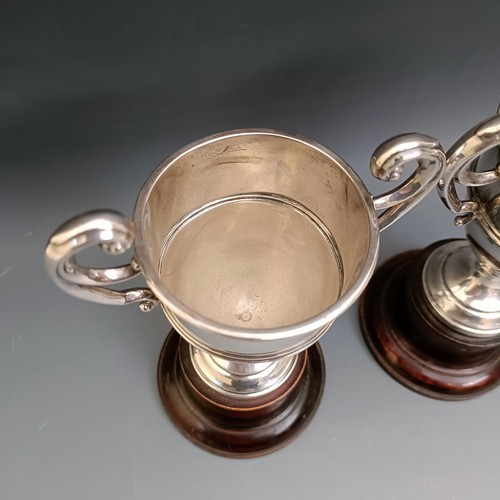 556 - A pair of modern silver two handled trophy cups, 4.7 ozt, 11.5 cm high, on turned wooden stands, Lav... 