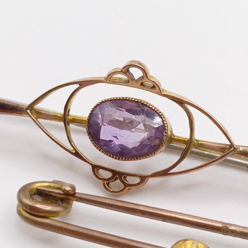 65 - A 9ct gold and purple stone bar brooch, and three other brooches (4)