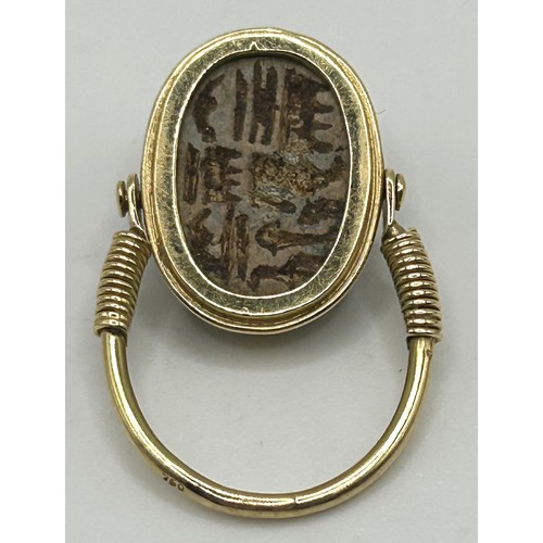 27 - A yellow coloured metal hinged ring, inset with a scarab, the undersigned with hieroglyphics, ring s... 