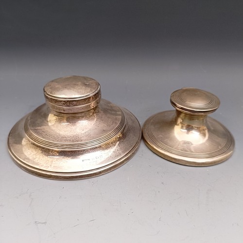 576 - A George V silver mounted capstan inkwell, 12 cm diameter, and another 8.5 cm (2)