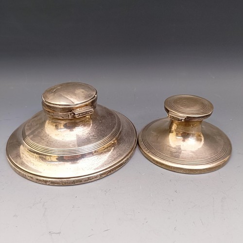 576 - A George V silver mounted capstan inkwell, 12 cm diameter, and another 8.5 cm (2)