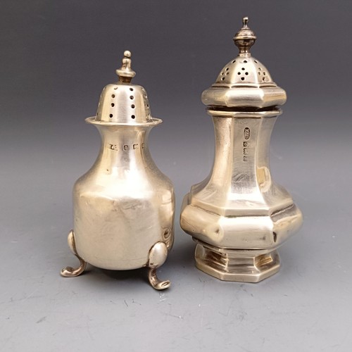 580 - A George V silver candlestick, base filled, and two pepperpots, various dates and marks