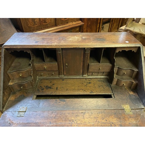 864 - An 18th century oak and mahogany crossbanded bureau, the fall front revealing a well, drawers and pi... 