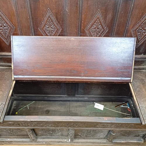 874 - A 17th century style carved oak settle, with a painted leather panel to the seat and arms, 130 cm wi... 