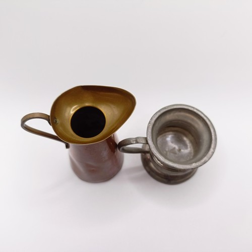 819 - A pewter drinking vessel, with a brass and copper jug (2)