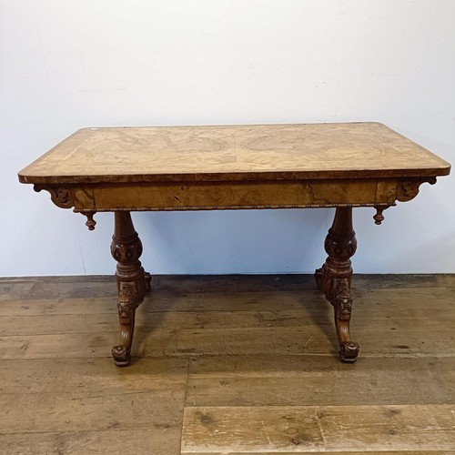 885 - A late 19th/early 20th century walnut library table, with two frieze drawers, on carved twin end sup... 