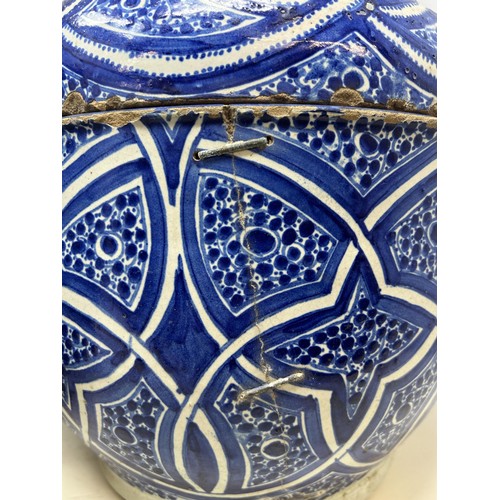 706 - A pair of Moorish pottery style vases and covers, with blue glazed decoration, 35 cm high