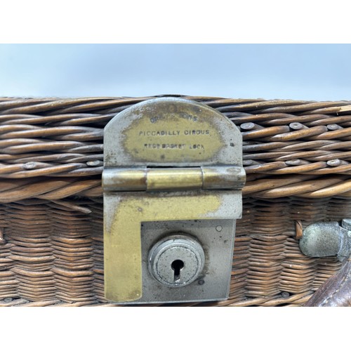 763 - A late 19th/early 20th century whicker picnic basket, contents to include two plates, two forks, a k... 