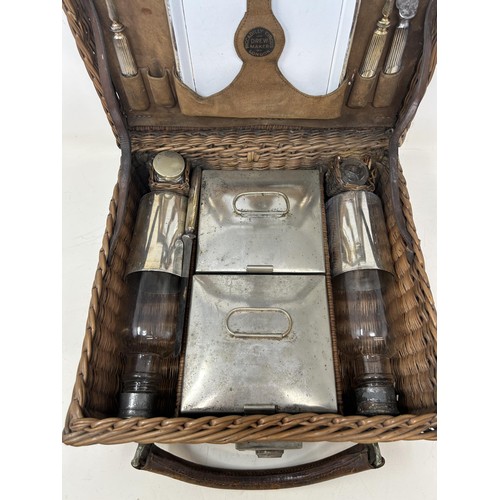 763 - A late 19th/early 20th century whicker picnic basket, contents to include two plates, two forks, a k... 