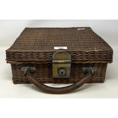 763 - A late 19th/early 20th century whicker picnic basket, contents to include two plates, two forks, a k... 