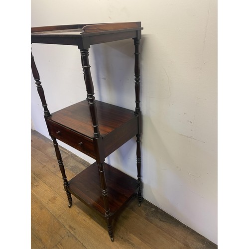 891 - A 19th century rosewood whatnot, with a central drawer, raised on castors, 133 x 56 cm