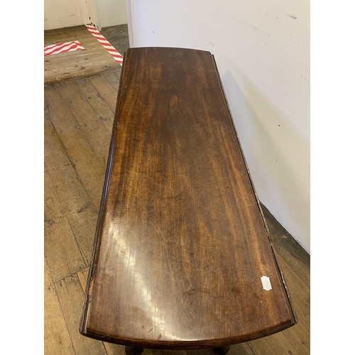 844 - A 19th century mahogany drop leaf table, on turned legs to pad feet, 145 cm wide