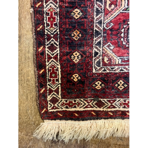 963 - A red ground rug, 190 x 112cm