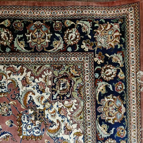 964 - A Persian Qum silk pink ground rug, 205 x 132 cm