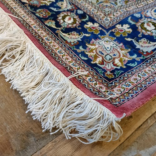 964 - A Persian Qum silk pink ground rug, 205 x 132 cm