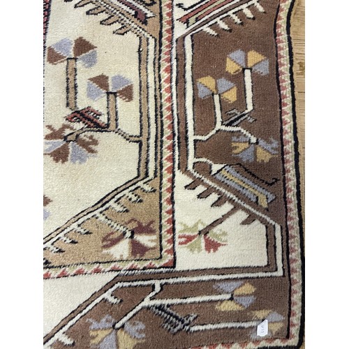 962 - A red ground rug, 105 x 80 cm, a cream ground rug, 150 x 95 cm, a cream ground rug, 225 x 125 cm, a ... 