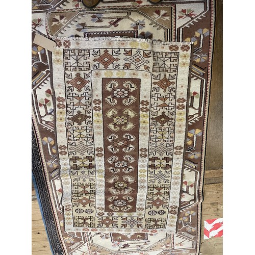 962 - A red ground rug, 105 x 80 cm, a cream ground rug, 150 x 95 cm, a cream ground rug, 225 x 125 cm, a ... 