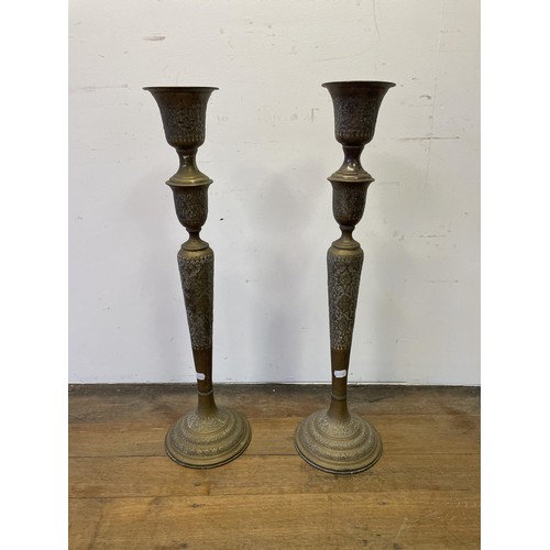 1700 - A large pair of Islamic brass candlesticks, 86 cm high