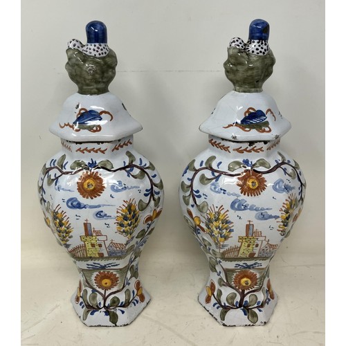 1314 - A Dutch Delft polychrome garniture, of four vases, the largest 31 cm high (4)