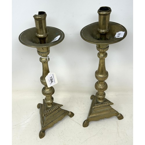 1364 - A pair of 17th century brass candlesticks, on triangular bases, 36 cm high