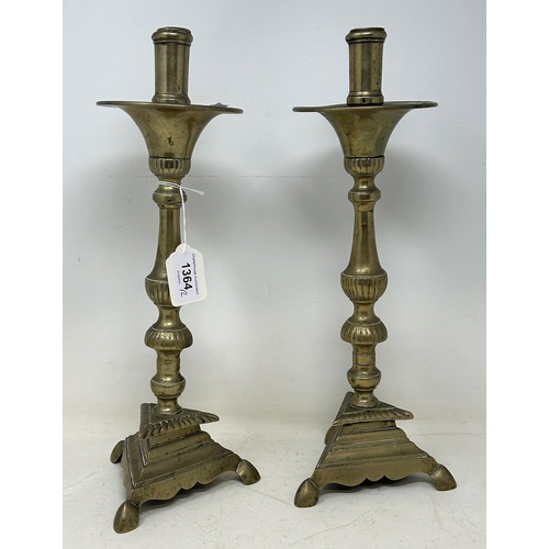 1364 - A pair of 17th century brass candlesticks, on triangular bases, 36 cm high