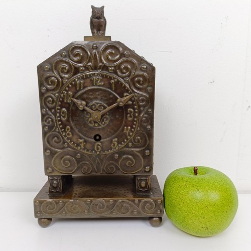 1515 - An Art Nouveau style mantel clock, with Arabic numerals, in a hammered and embossed anodised metal c... 