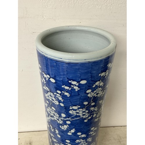 1350 - A Chinese cylindrical stick stand, decorated prunus in underglaze blue, cracked 60 cm high