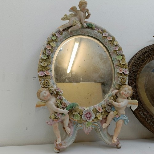 1425 - A wall mirror, the pierced brass frame surmounted by a cherub, 28 cm high, and a Sitzendorf style po... 