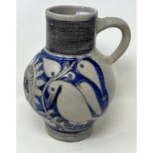 1444 - An 18th century German Westerwald stoneware jug, with GR cypher, 22 cm high