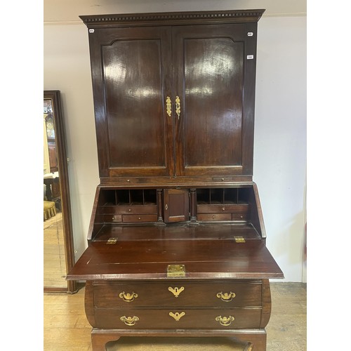 1564 - An 18th century mahogany bombe bureau bookcase, the top having two panel doors, to reveal adjustable... 