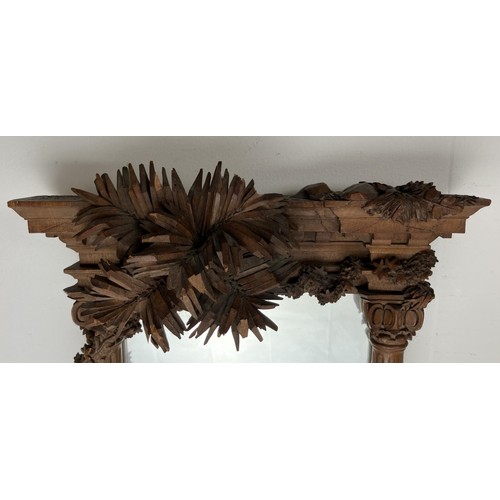 1679 - A late 19th/early 20th century carved walnut framed mirror, in the form of a overgrown ruin, 43 x 32... 