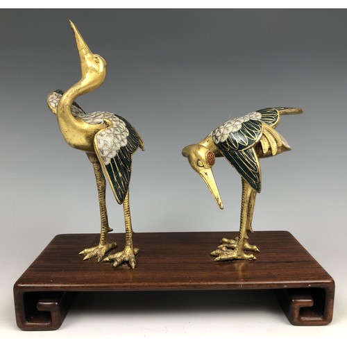 1595 - A pair of Chinese cloisonné figures of cranes, probably Qing Dynasty, 18th century, on an associated... 