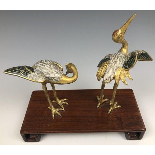 1595 - A pair of Chinese cloisonné figures of cranes, probably Qing Dynasty, 18th century, on an associated... 