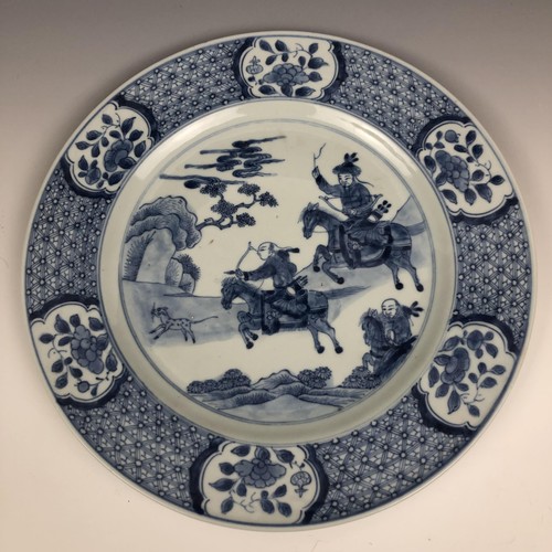 1603 - A Chinese blue and white plate, decorated huntsmen on horseback, 26.5 cm diameter