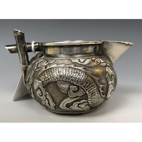 1622 - A Chinese silver coloured metal cream jug, embossed a dragon and with a faux bamboo handle, 5 cm hig... 