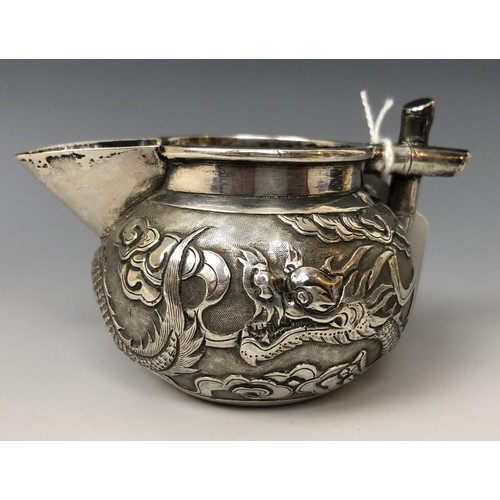 1622 - A Chinese silver coloured metal cream jug, embossed a dragon and with a faux bamboo handle, 5 cm hig... 