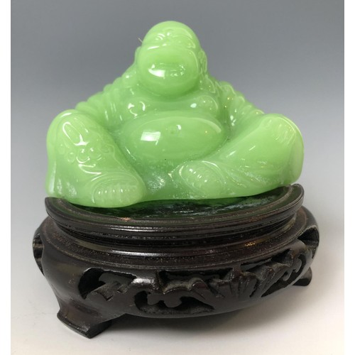 1624 - A Chinese green Buddha, 7 cm high, on an associated carved wooden base