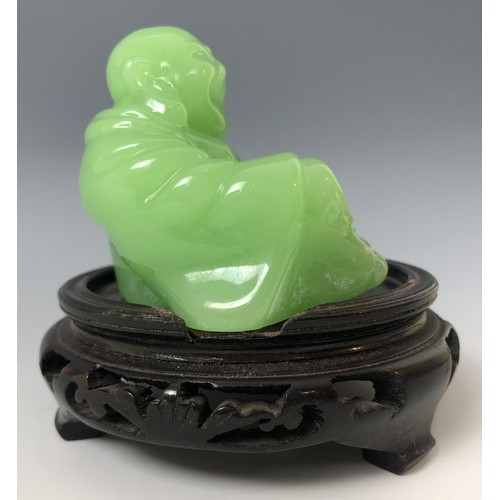 1624 - A Chinese green Buddha, 7 cm high, on an associated carved wooden base