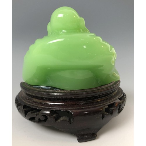 1624 - A Chinese green Buddha, 7 cm high, on an associated carved wooden base