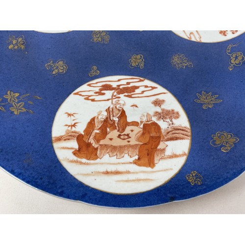 1505 - A Chinese powder blue charger, with three roundels, decorated figures in ironstone red, 40 cm diamet... 