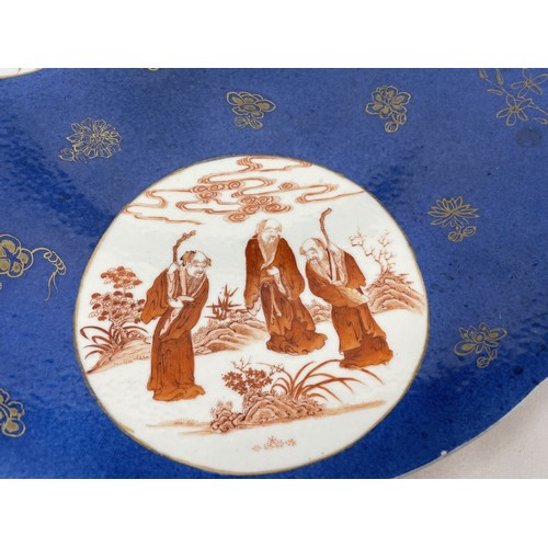 1505 - A Chinese powder blue charger, with three roundels, decorated figures in ironstone red, 40 cm diamet... 